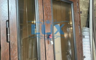 двустворчатая металлическая дверь с двумя стеклопакетами и ковкой с внутренней стороны